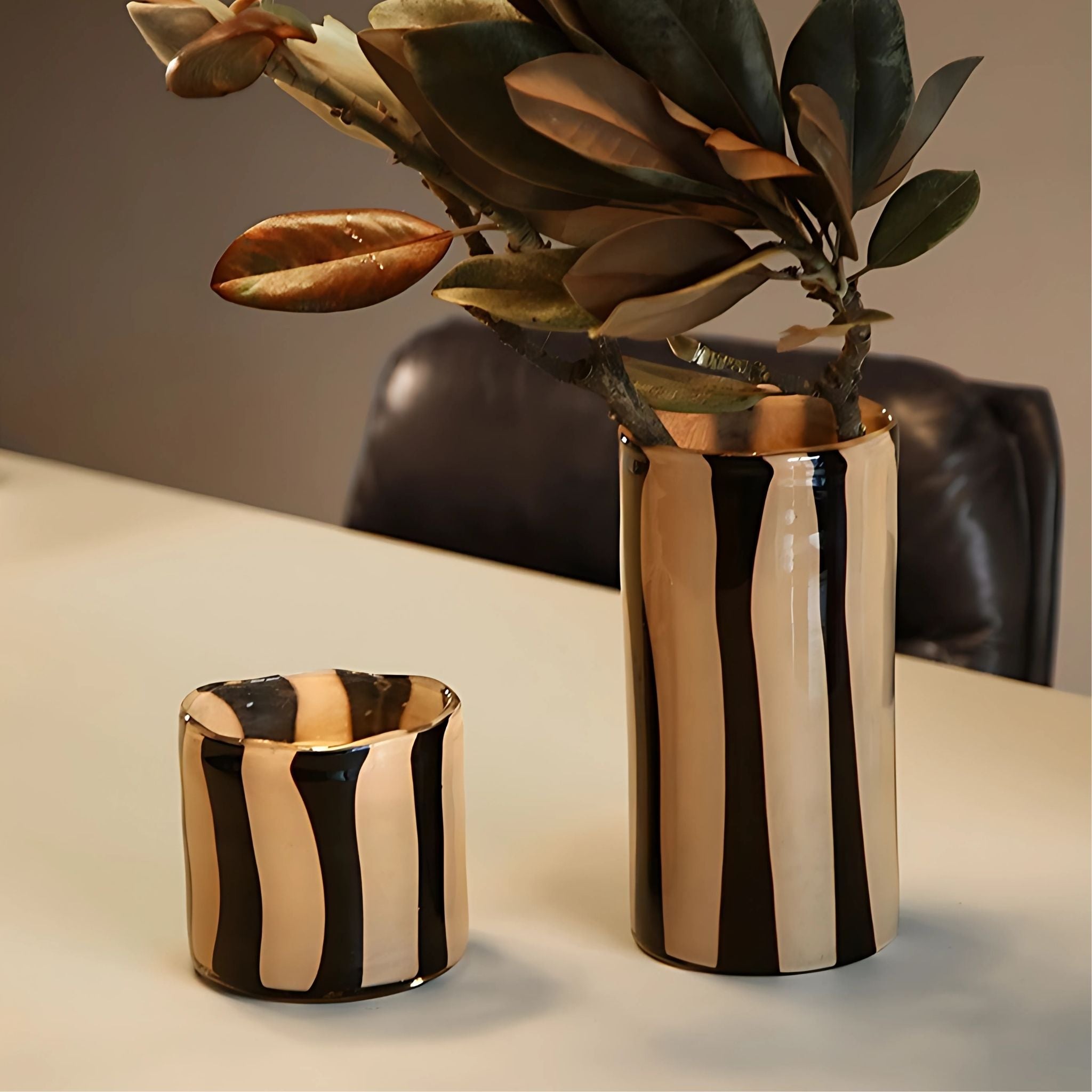 Beige & black stripe decorative glass vases on tabletop.