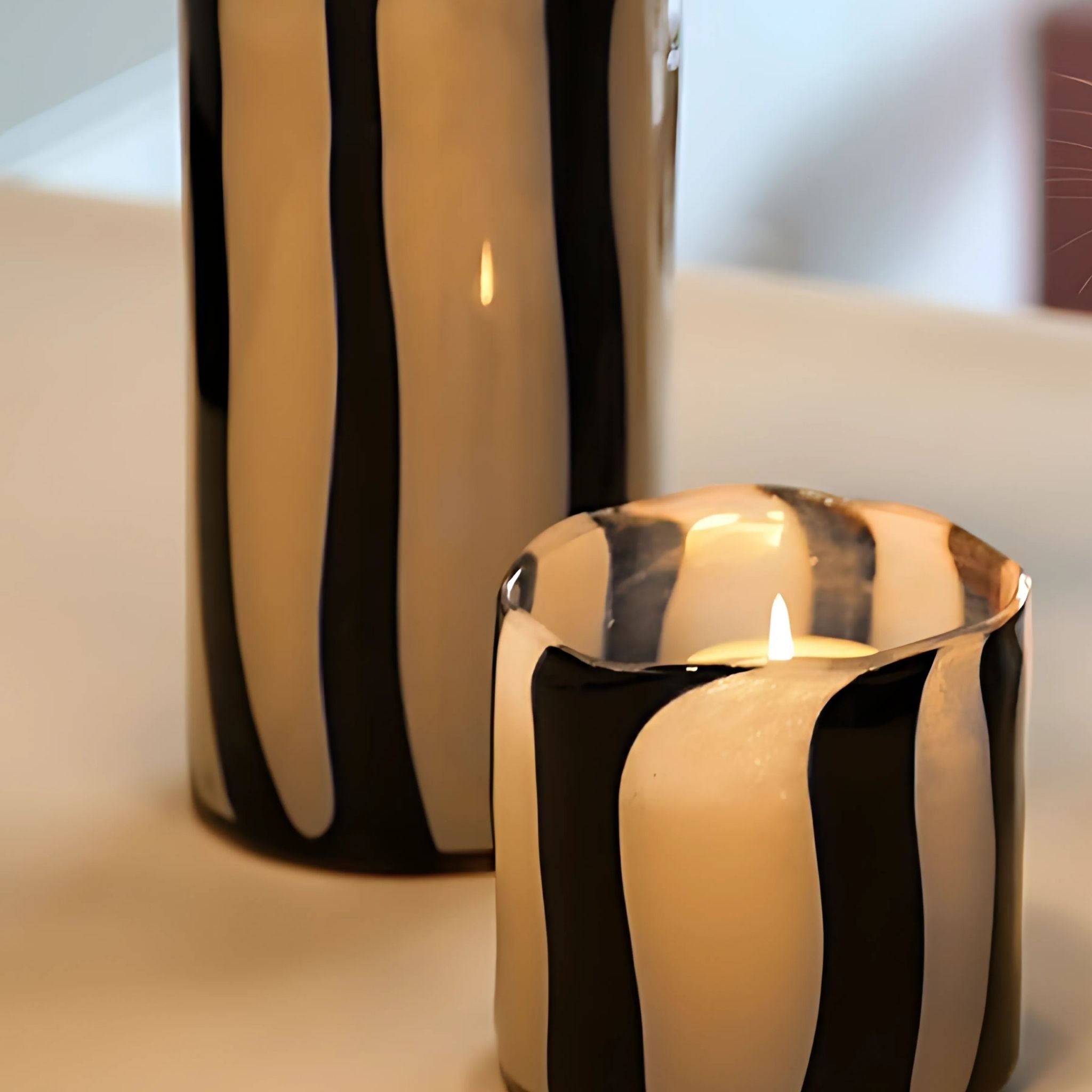 Glass striped candleholder decorative item on table top.