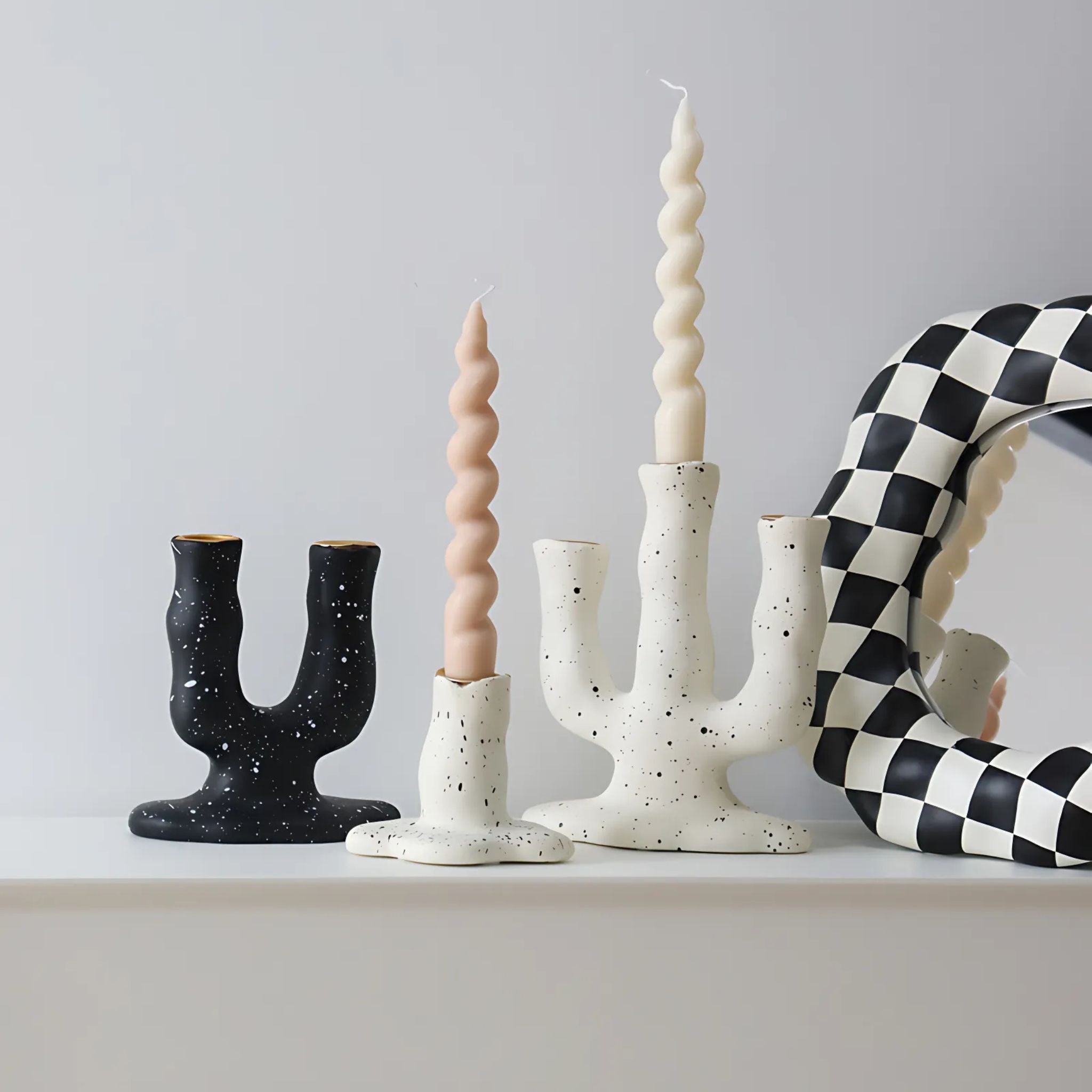 Black and whit arch shaped decorative candlestick holders for multiple candles.