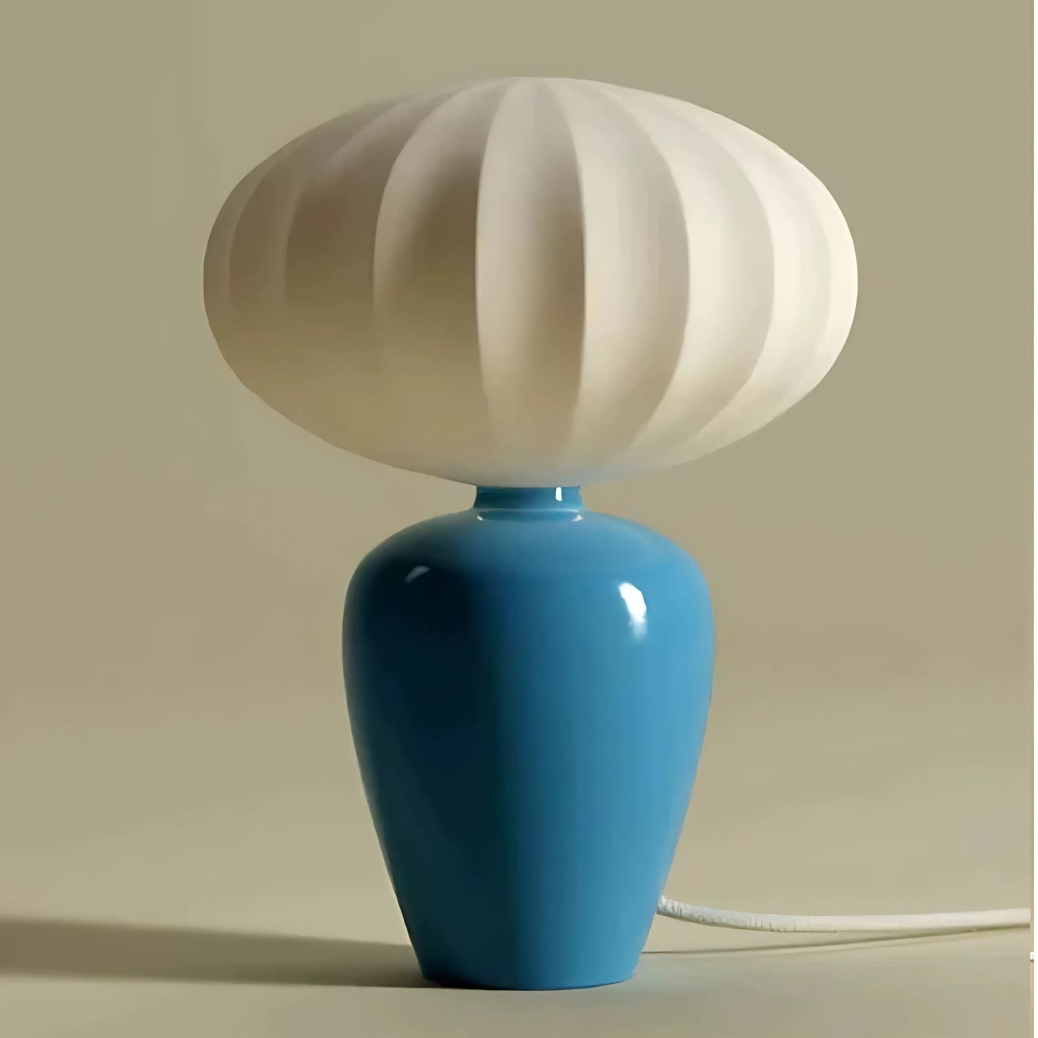Table lamp with blue ceramic base and white fabric lamp shade.