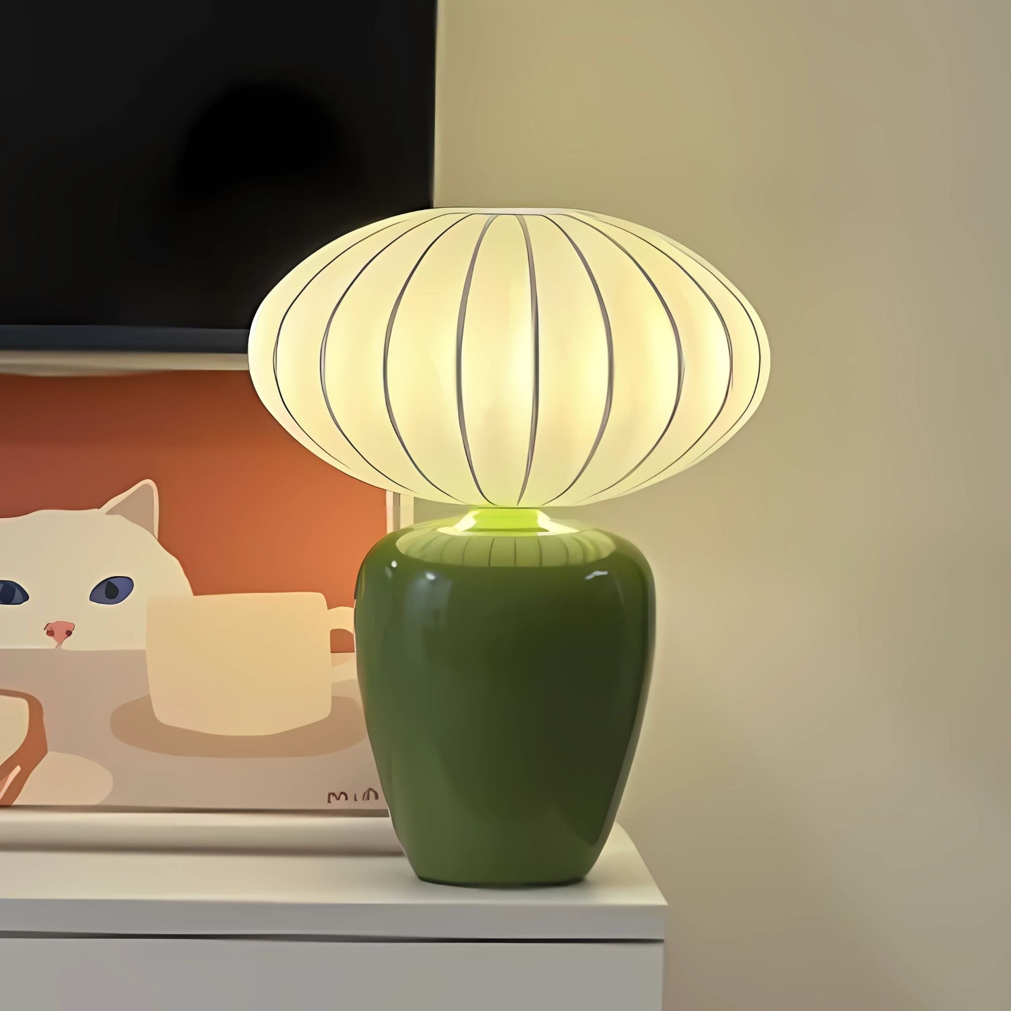 Green, ceramic base table lamp with round balloon lamp shade.