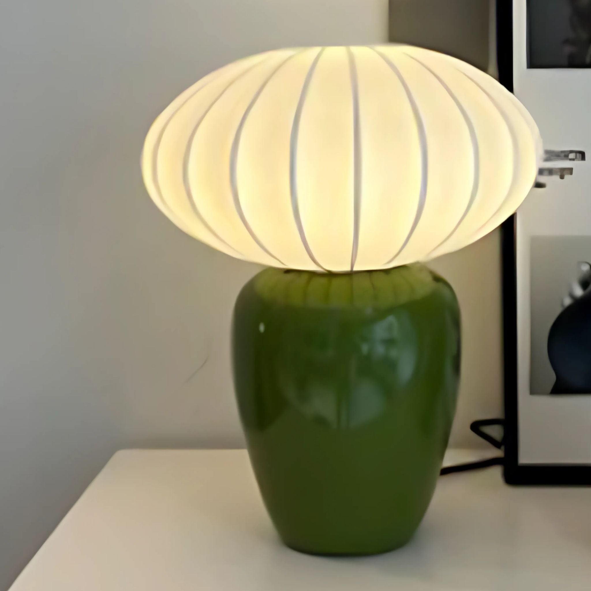Decorative, Nordic table lamp with green, ceramic base and white lamp shade.