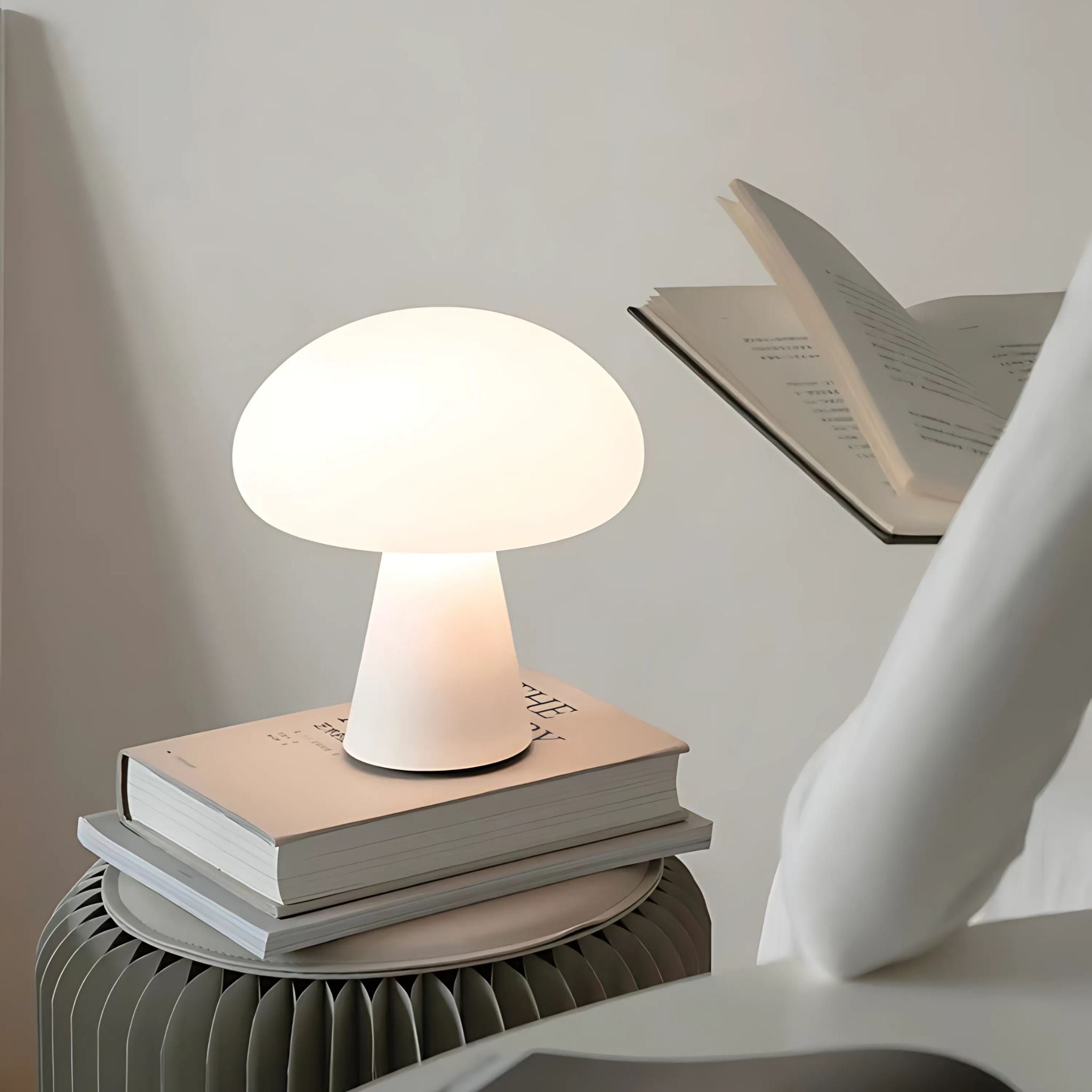 Scandinavian home decor cordless table lamp on top of stacked books on coffee table.