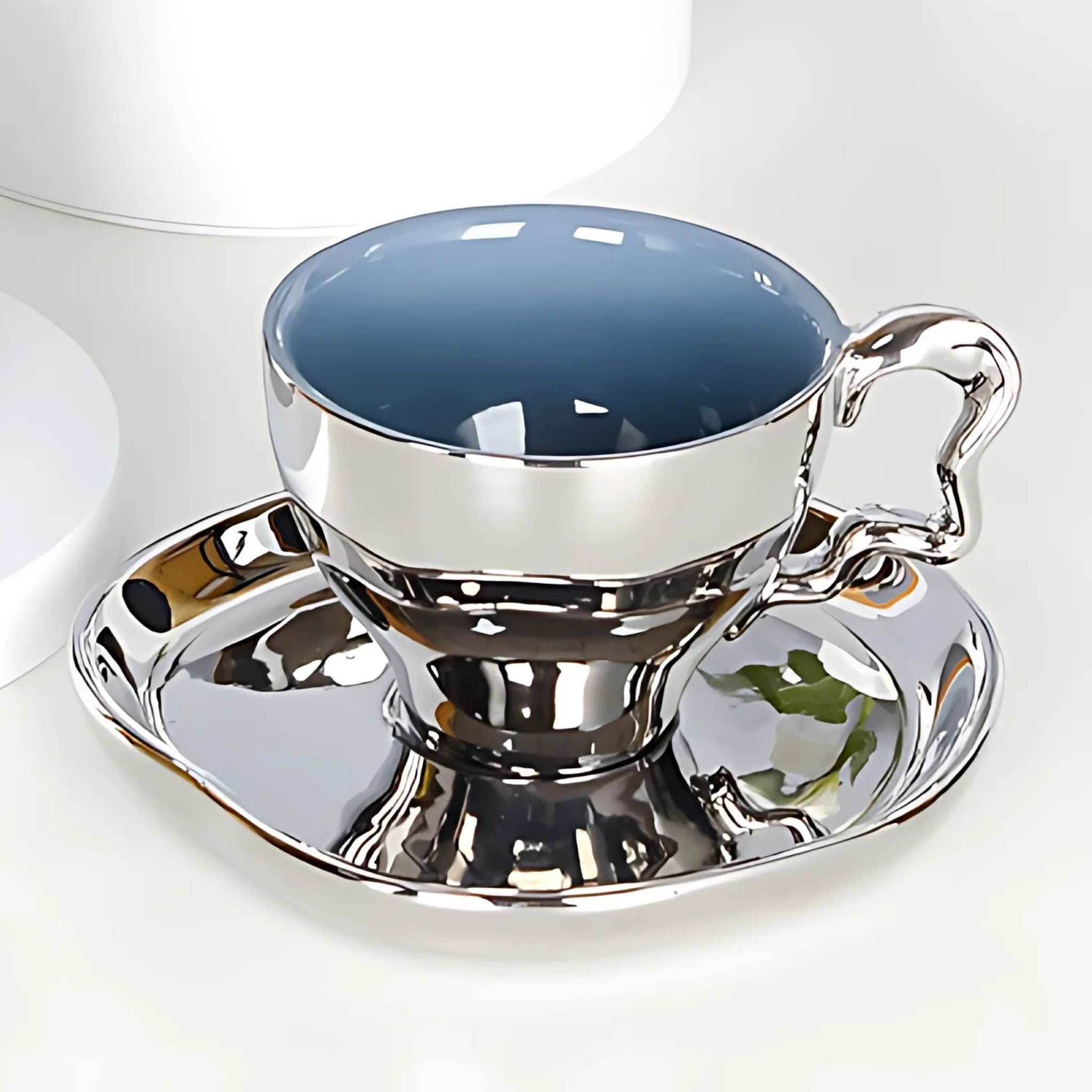 Silver chrome and blue ceramic tea set cup and saucer plate.