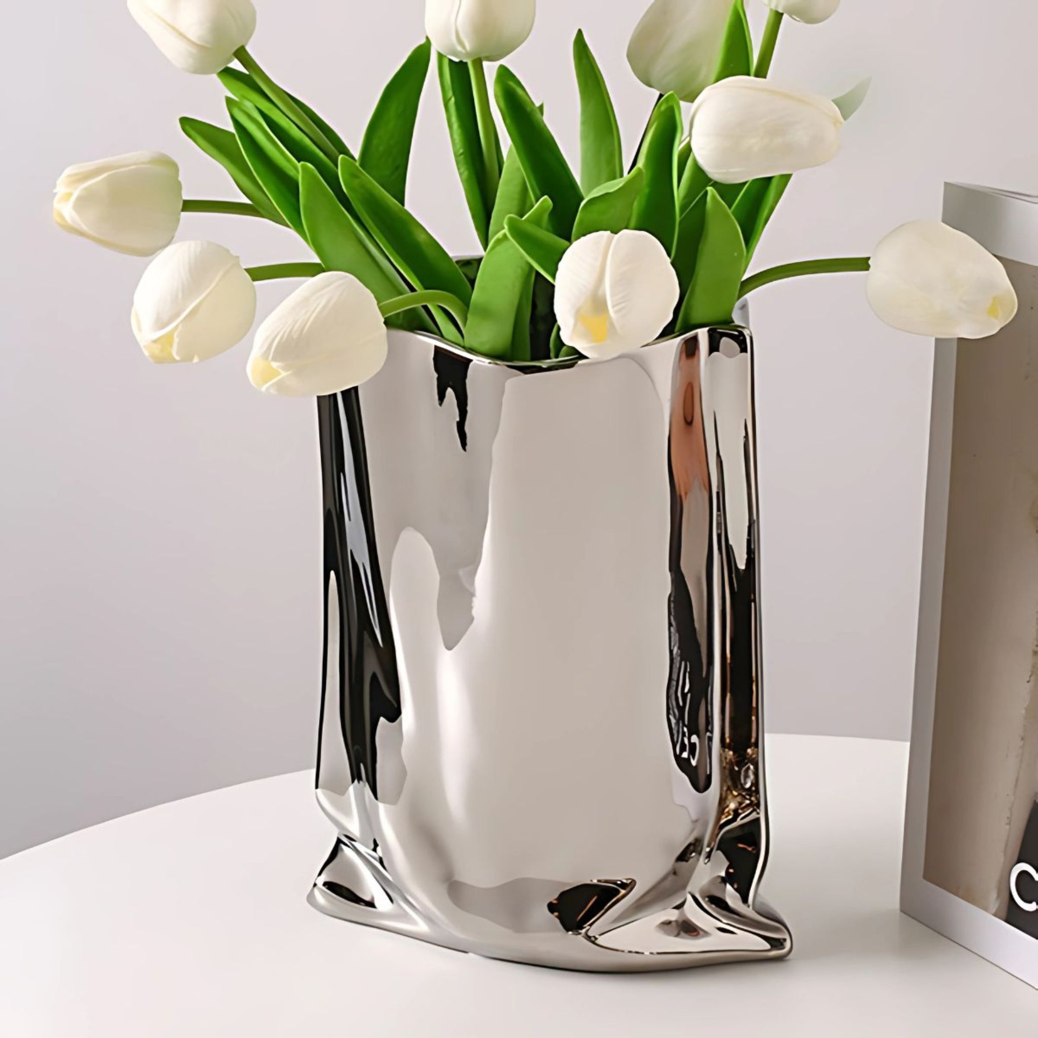 Electroplated, silver, ceramic vase with white tulips.