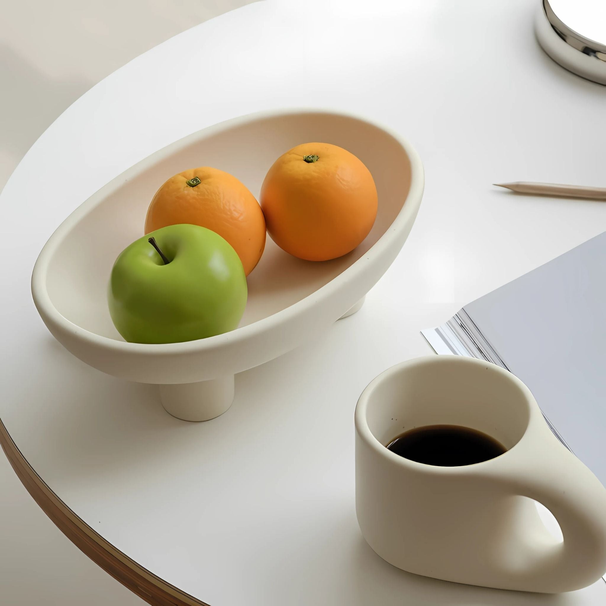 A white dining table with a ceramic fruit basket tray and a coffee mug.