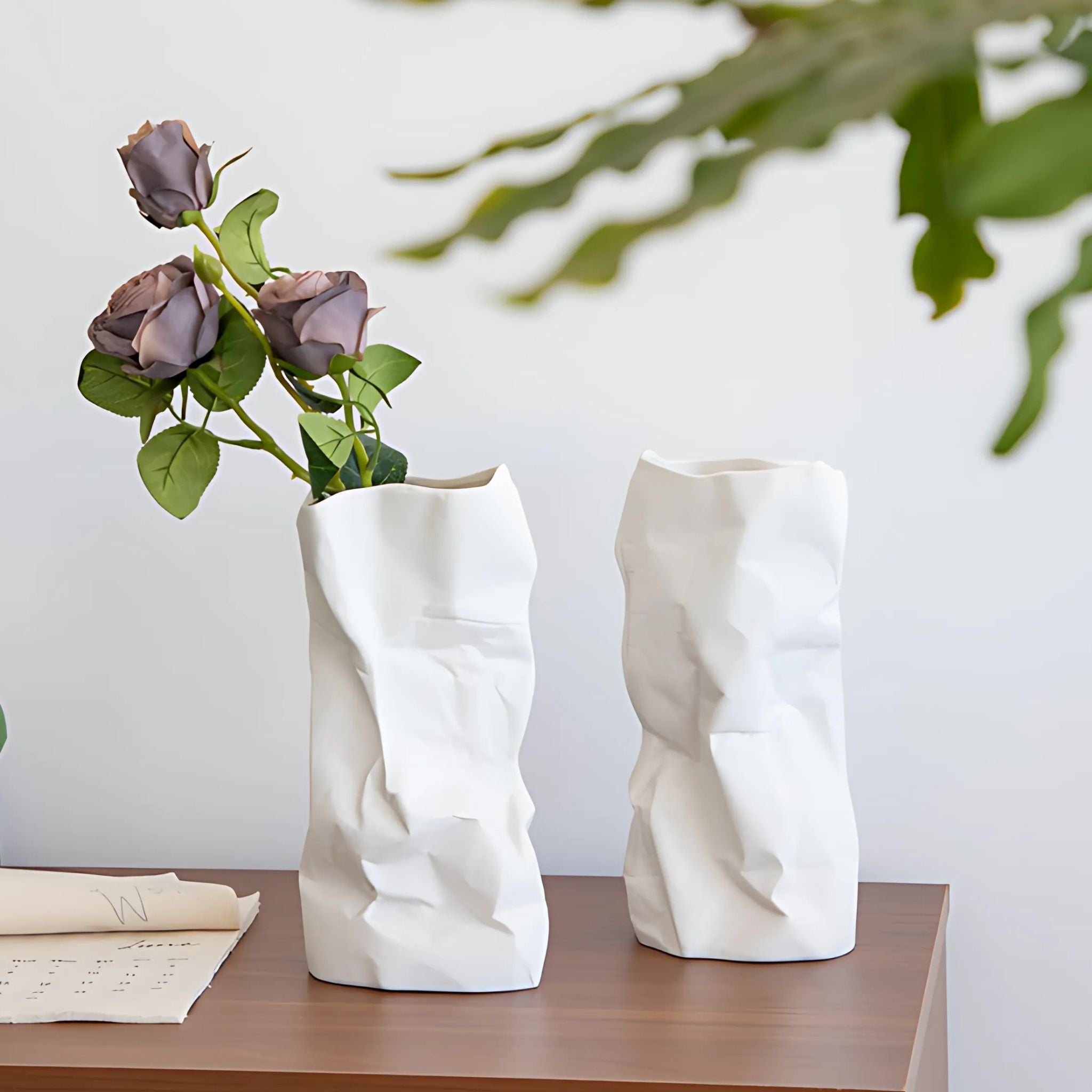 2 pieces of white, ceramic flower vases with paper bag design.