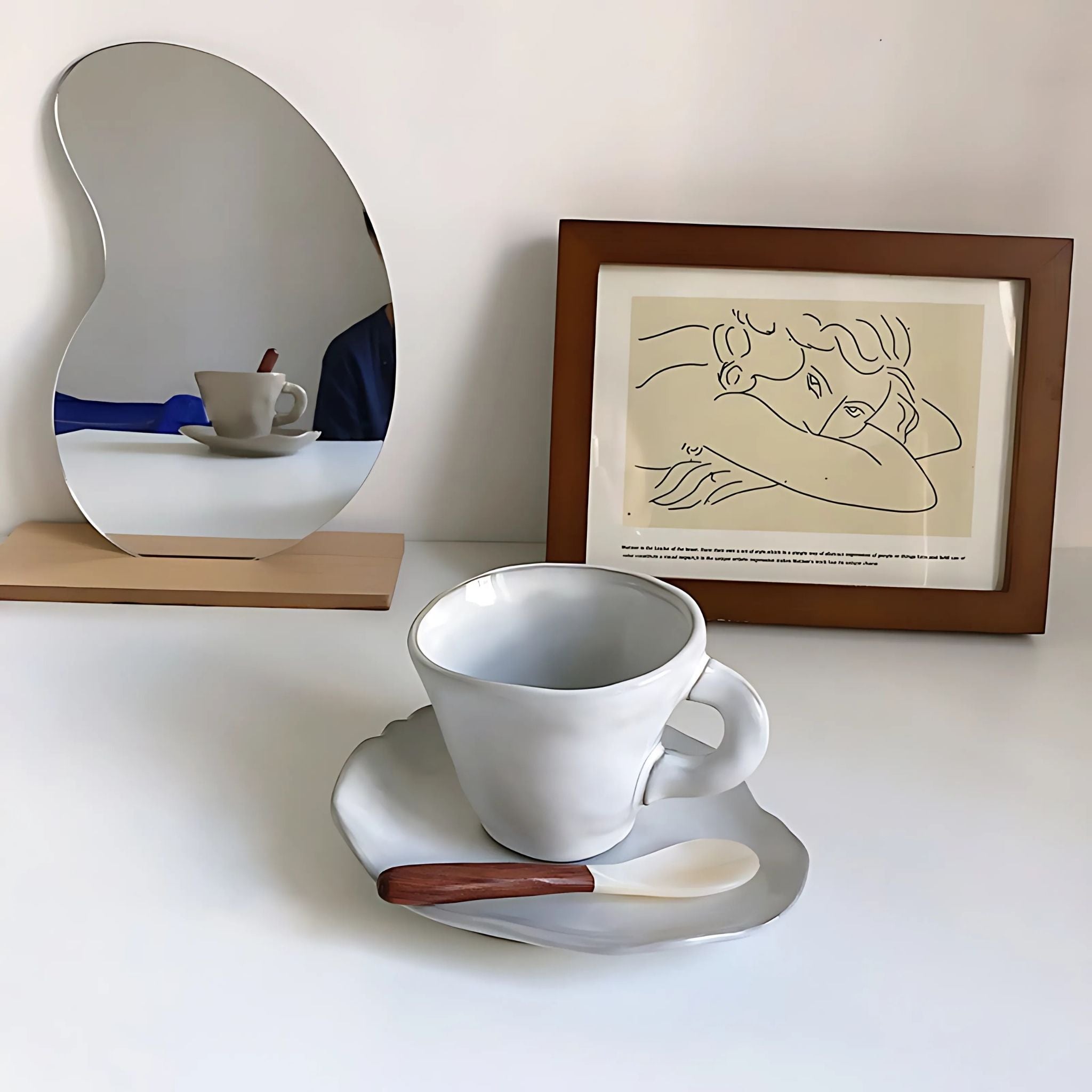White, ceramic coffee mug and saucer on top of table.