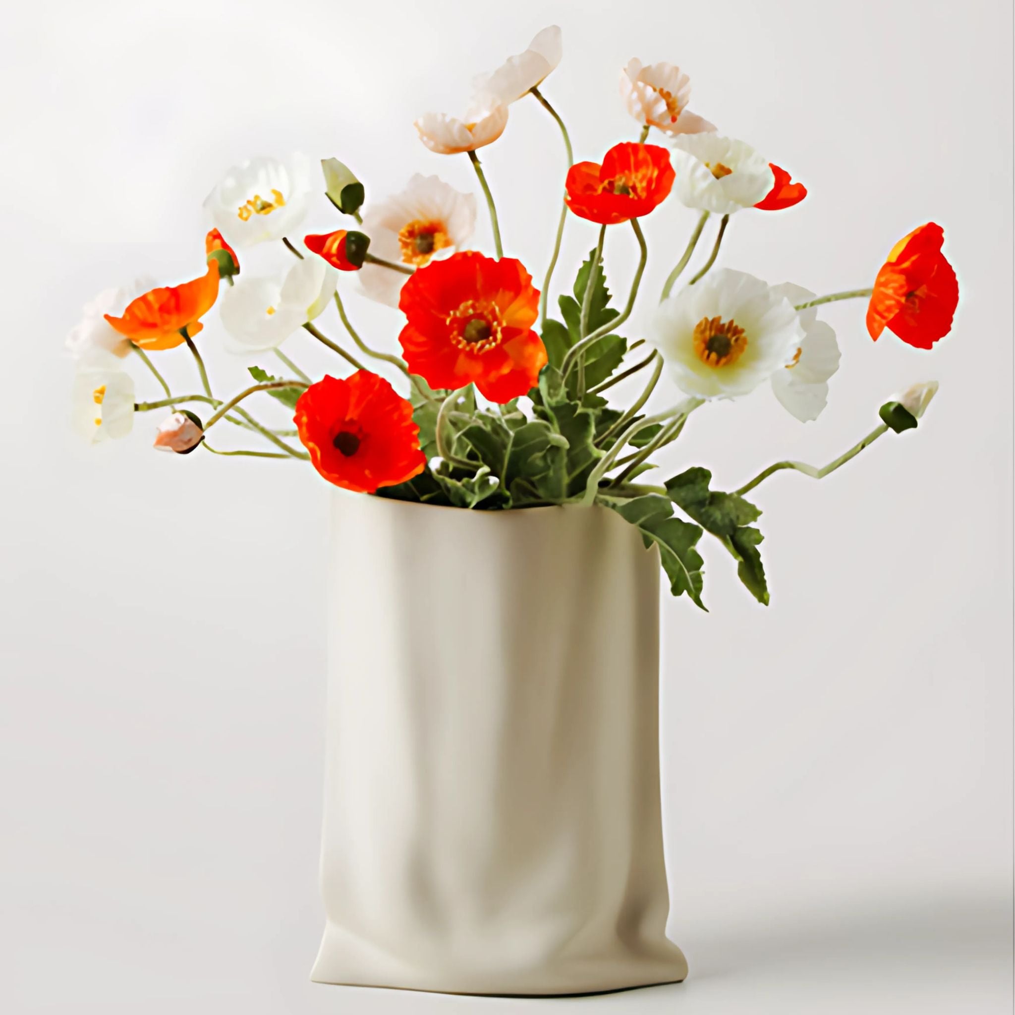 White, ceramic, bag vase with red flowers.