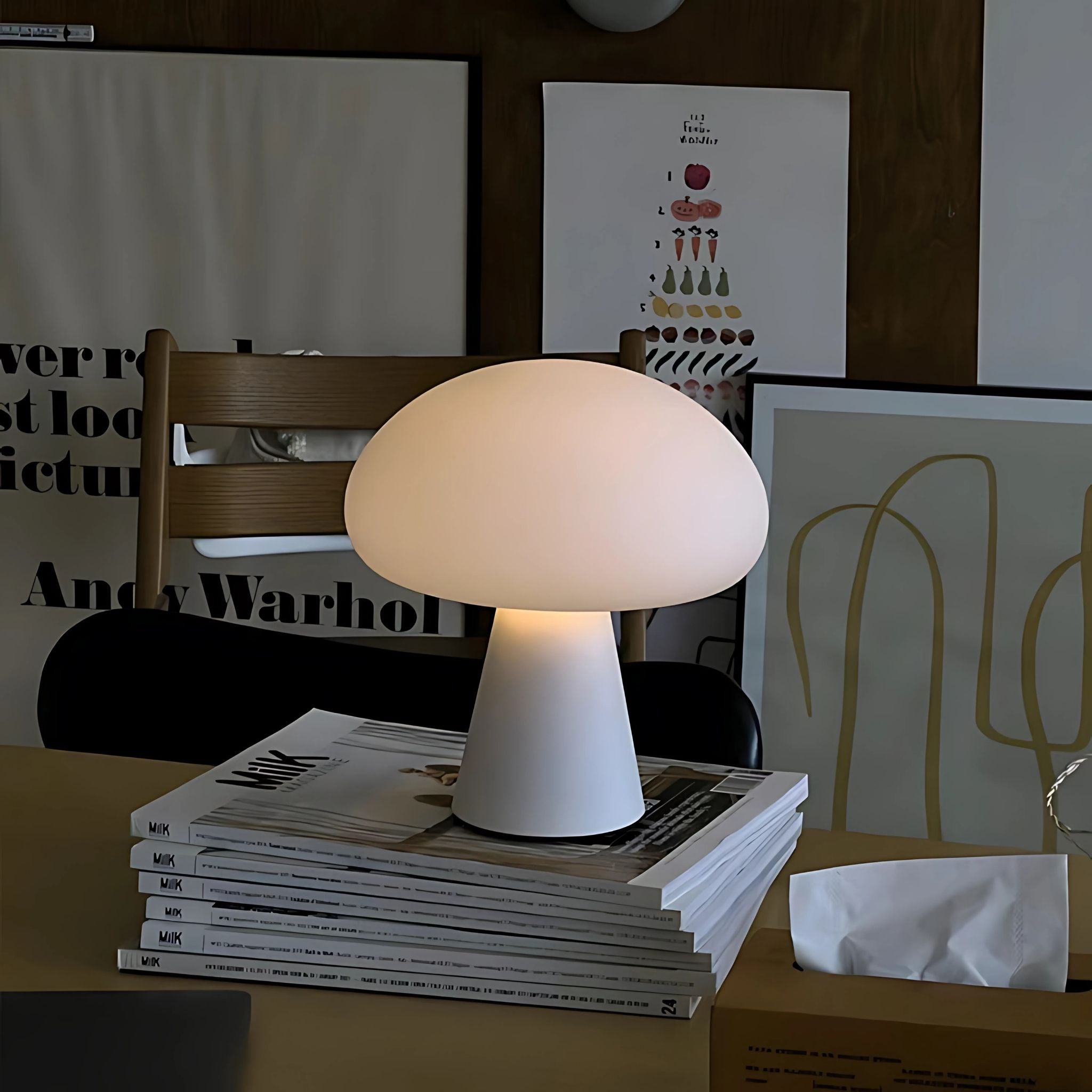 White, decorative, cordless table lamp on top of stacked fashion magazines in Nordic living room.