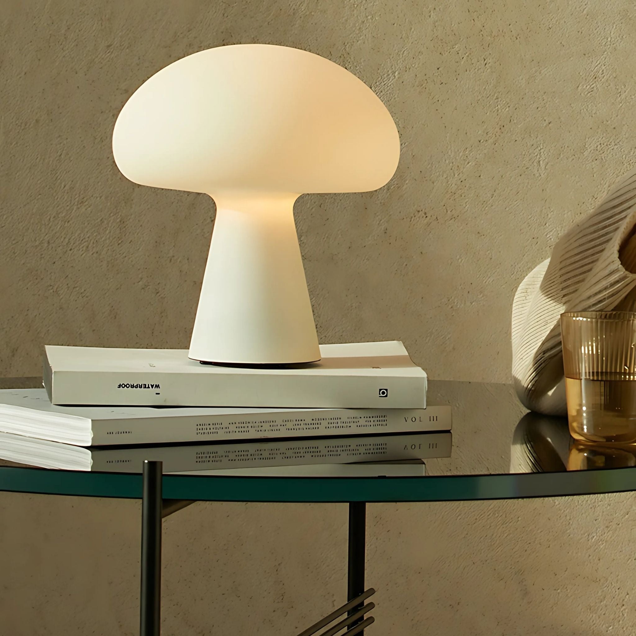 Nordic, white, cordless table lamp on top of books.