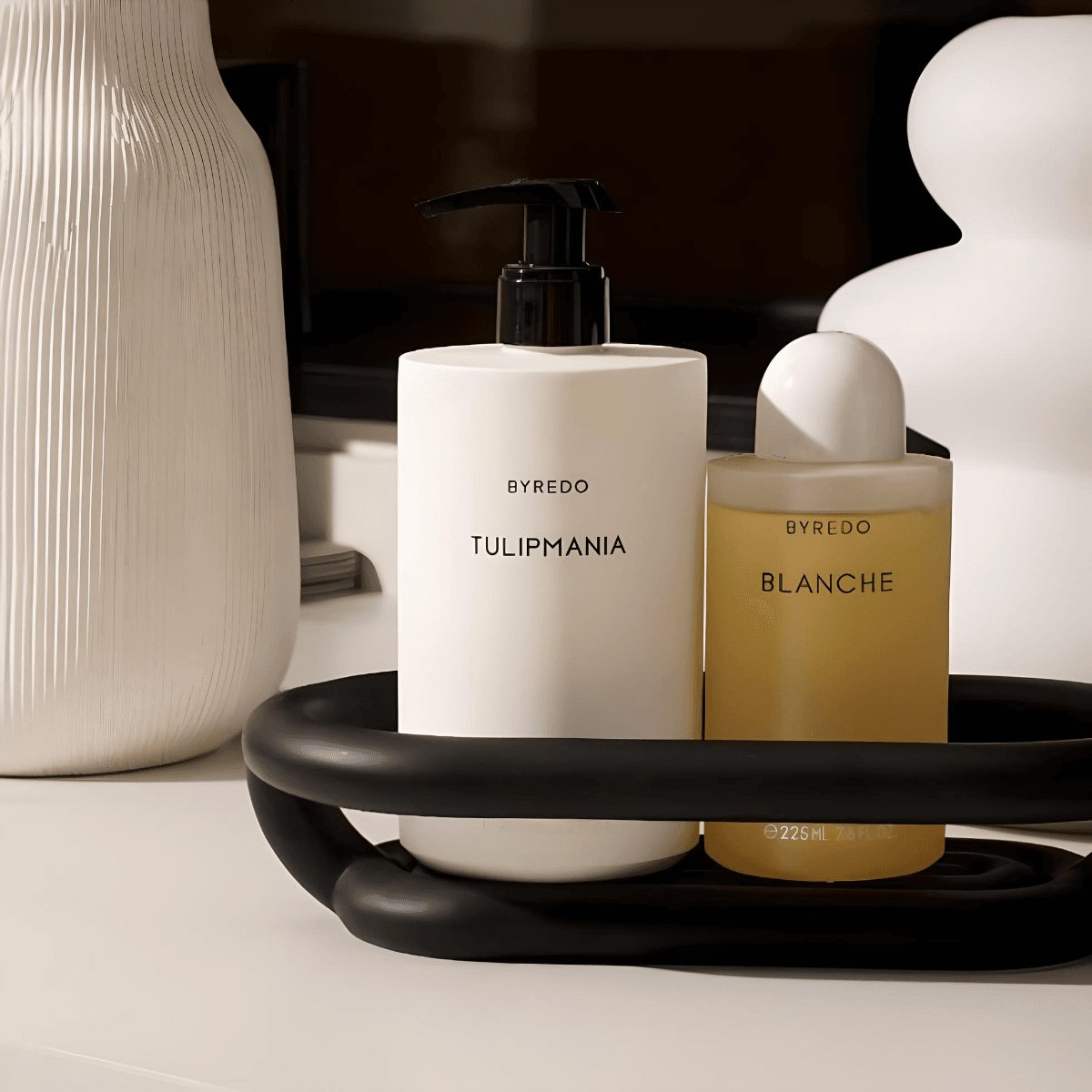 Elegant bathroom decor with black soap dish holding body was and lotion.