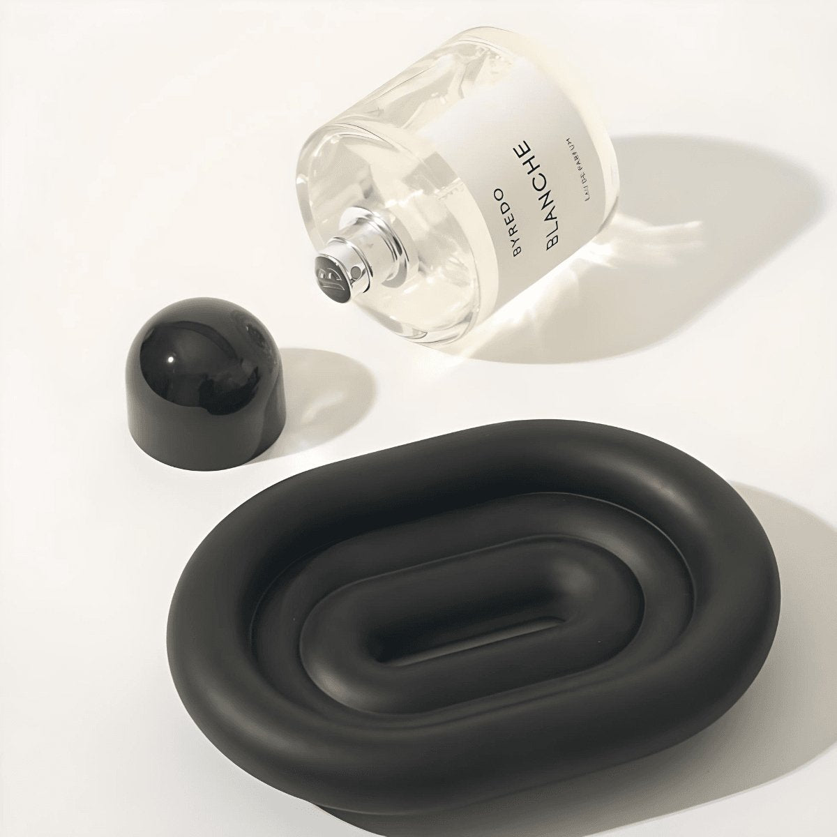 Black, resin oval soap dish and a perfume.