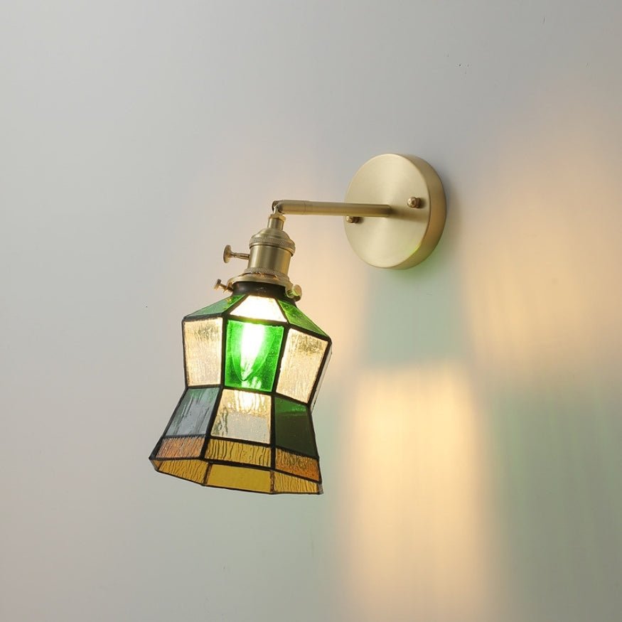Gold bedside wall lamp with colourful glass shade.