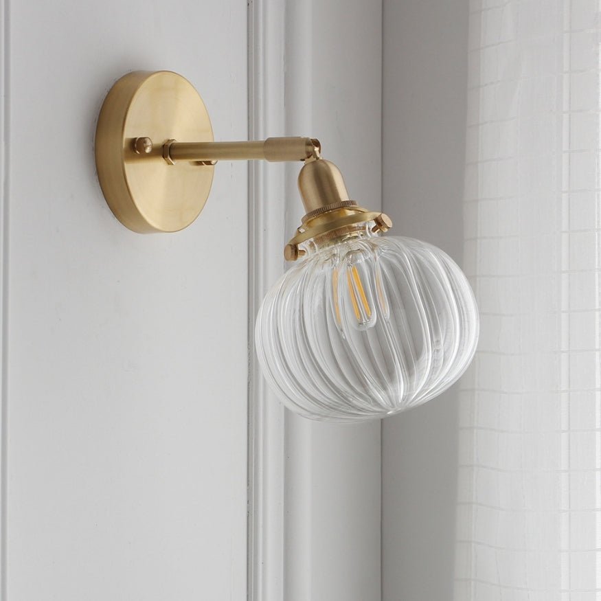 Bedside wall lamp - gold with glass ball shade.
