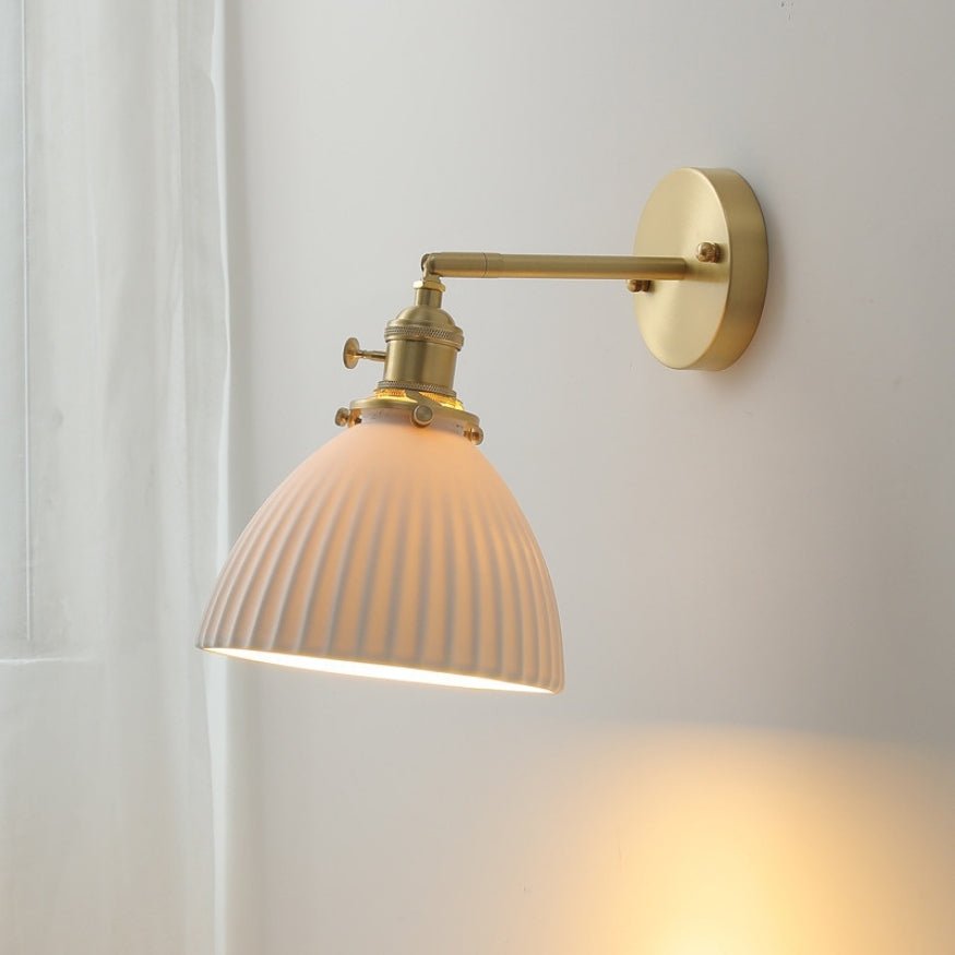 Bedside wall lamp with glass lamp shade.