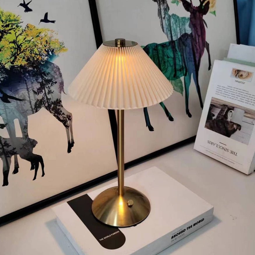 Beige shade gold metal portable table lamp.