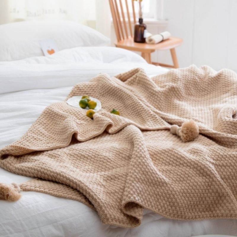 Beige knit tassel throw blanket.