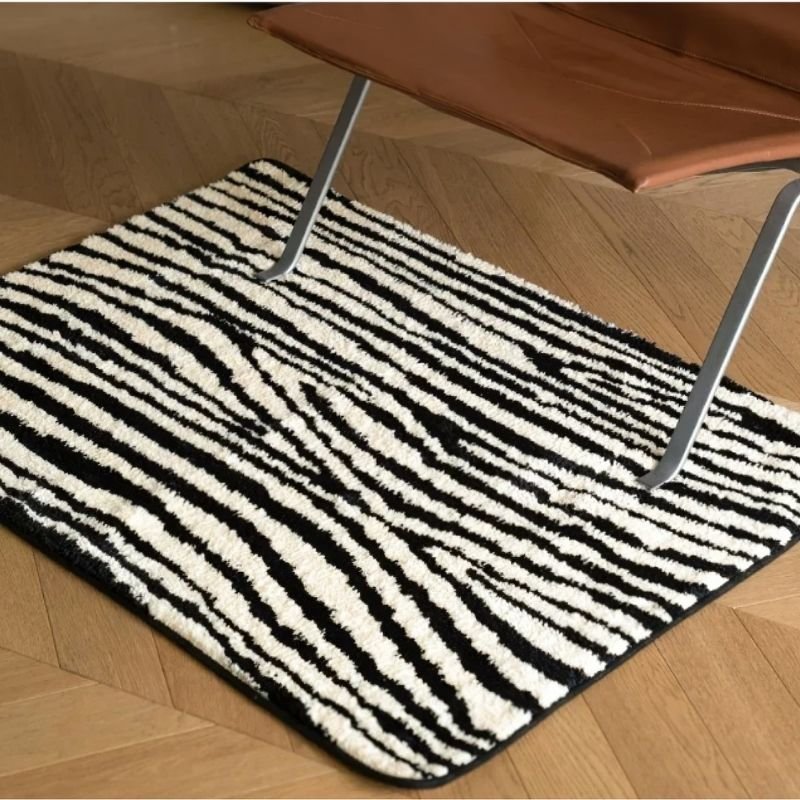 Black and white zebra stripe square floor rug.