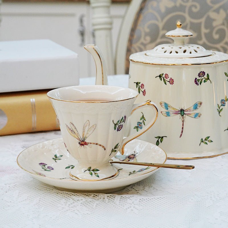 Dragonfly design white porcelain tea cup and saucer with matching tea pot.