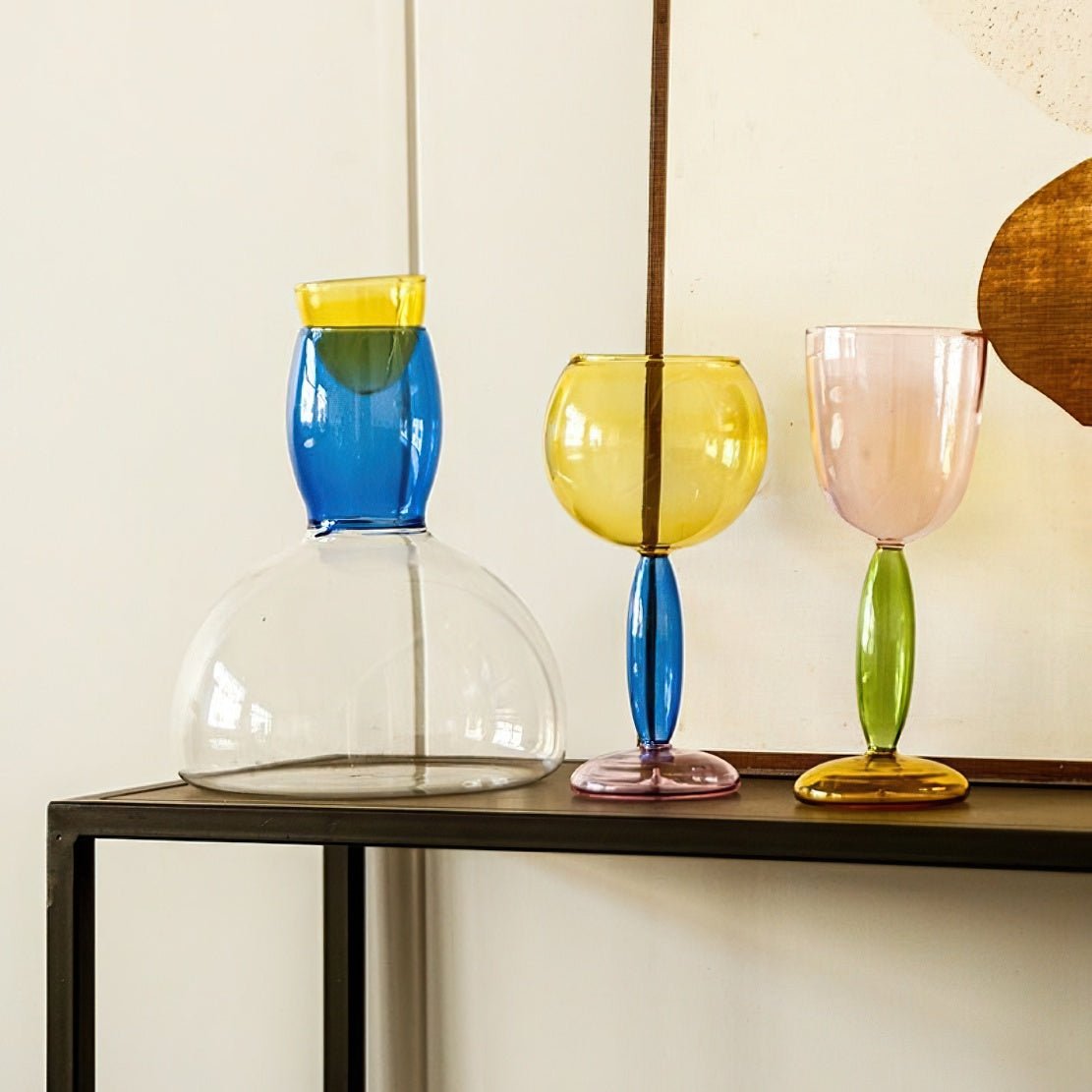Decorative dining tableware coloured glassware including a can and glass goblets.