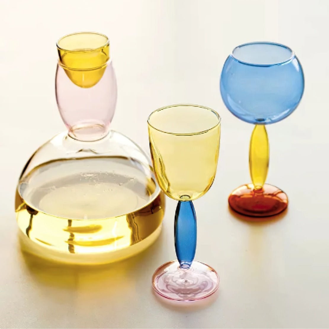 Colourful glassware including a can and wine glasses with vibrant colours.