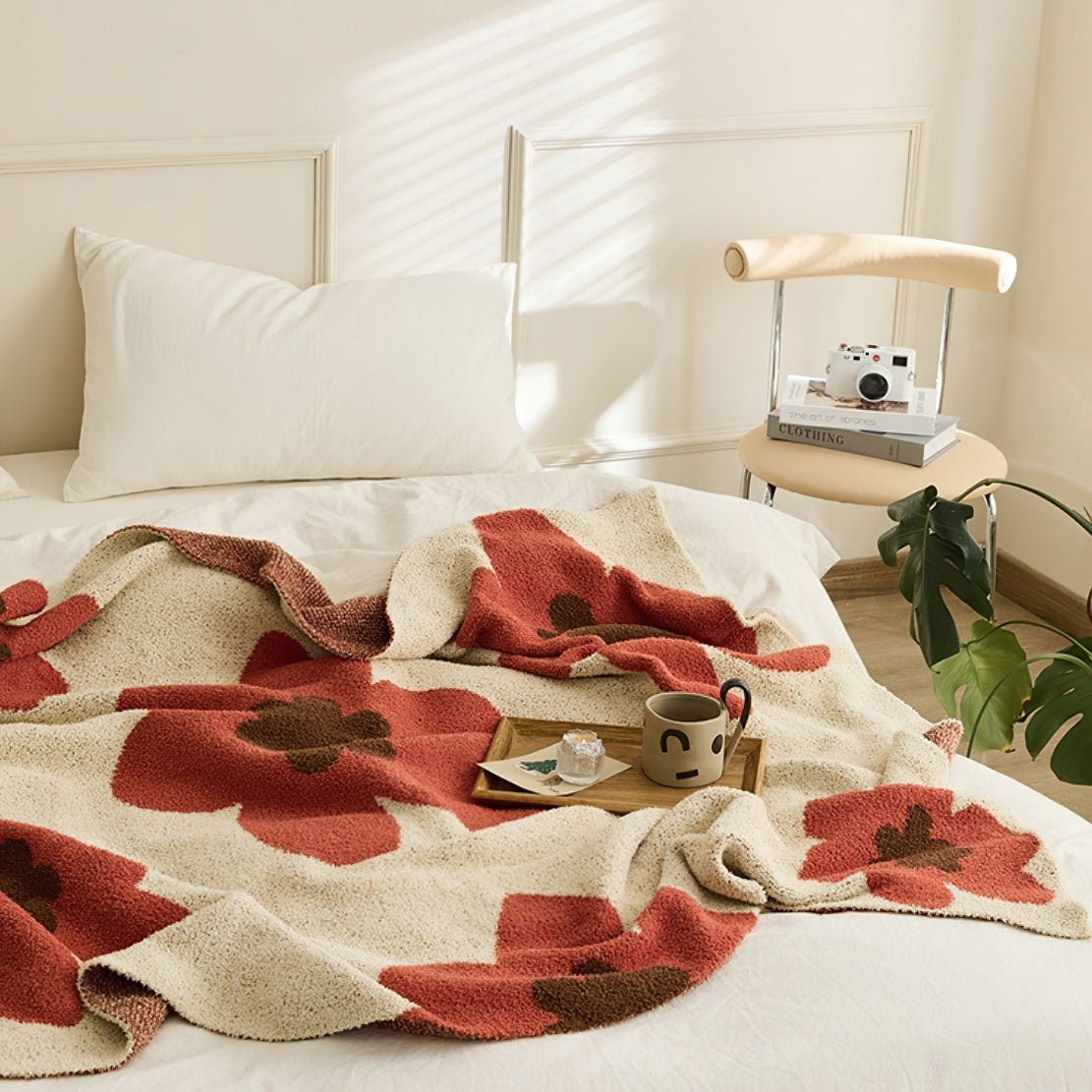 Red, beige and brown decorative throw blanket with floral patterns.