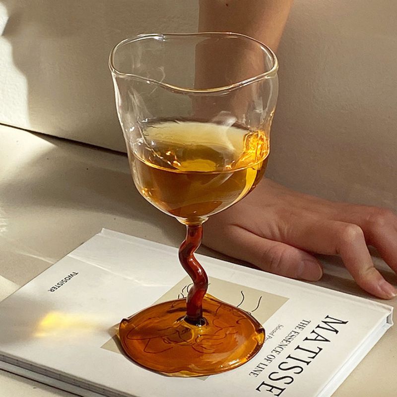 Irregular wine glass with brown stem.