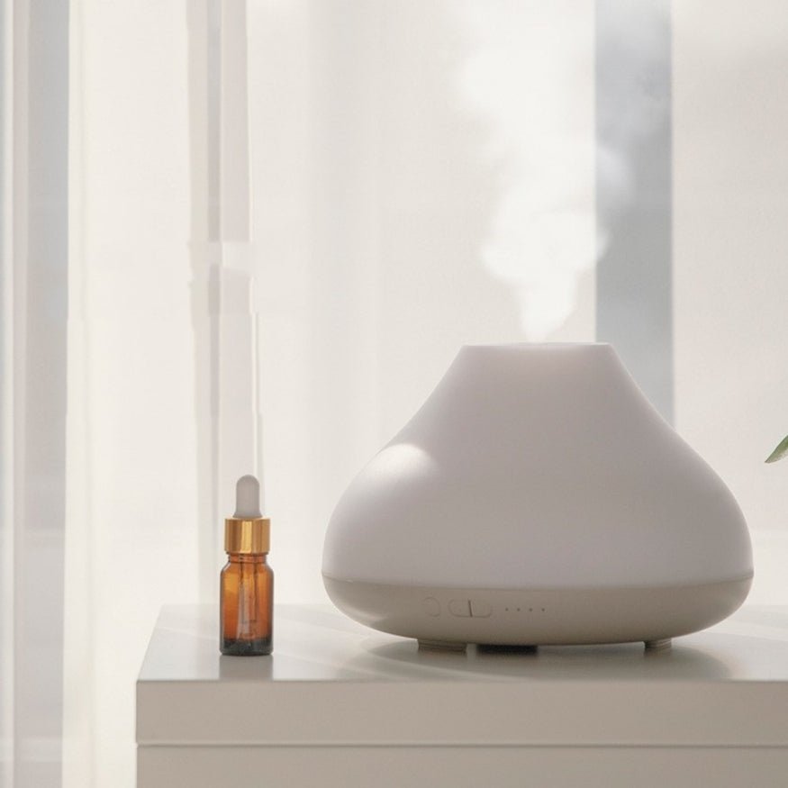 white minimalist aroma air humidifier on table with essential aroma oil.