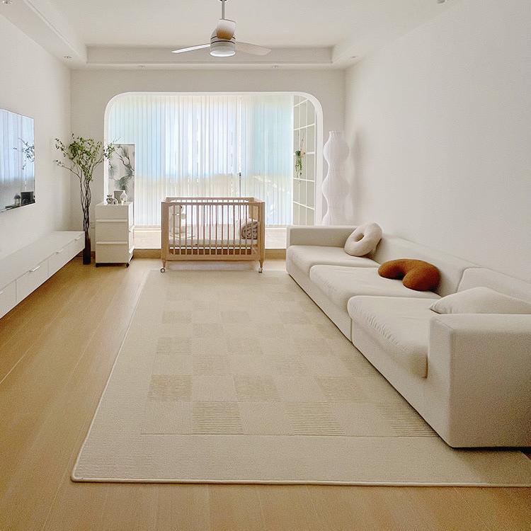 Modern, Nordic inspired living room design with white sofa and large, beige rectangular floor rug.