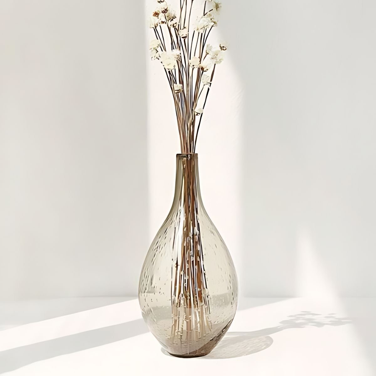 Grey bottle glass vase with white flowers.