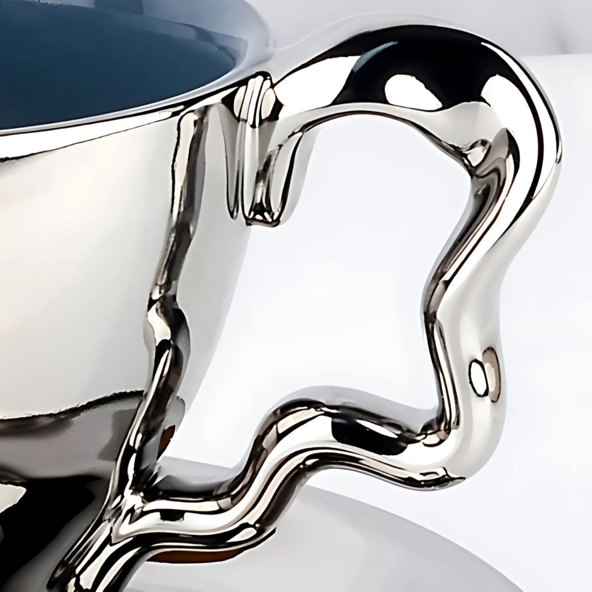 Silver ceramic chrome tea cut irregular handle close-up.