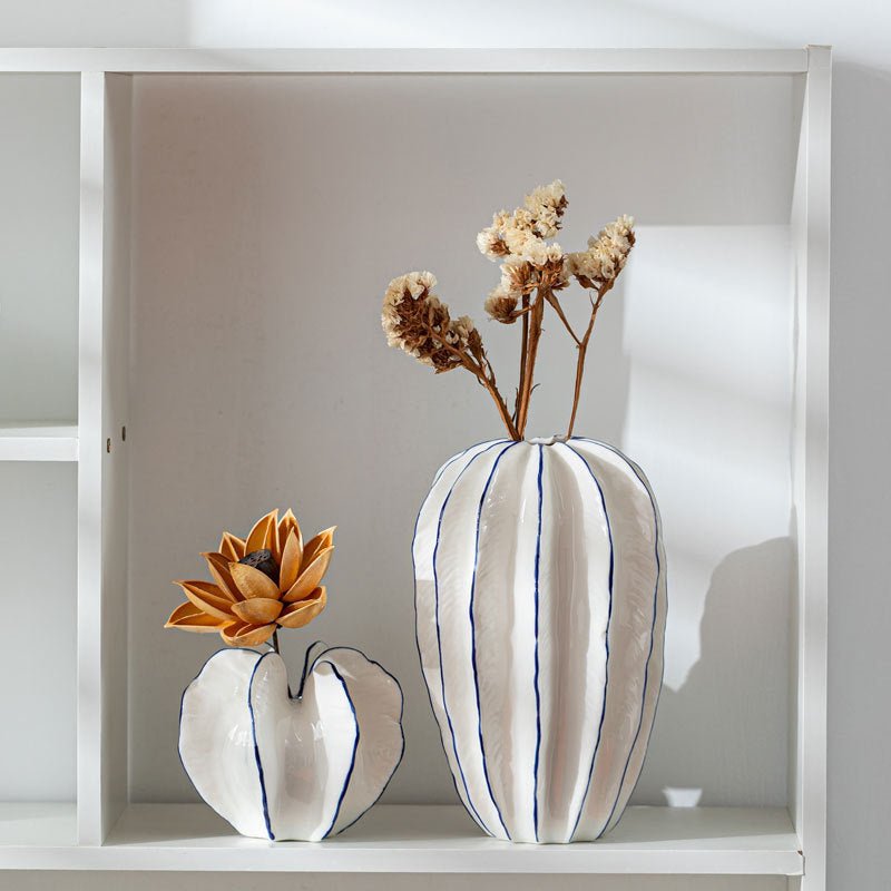 White ceramic flower vases holding dried flowers.