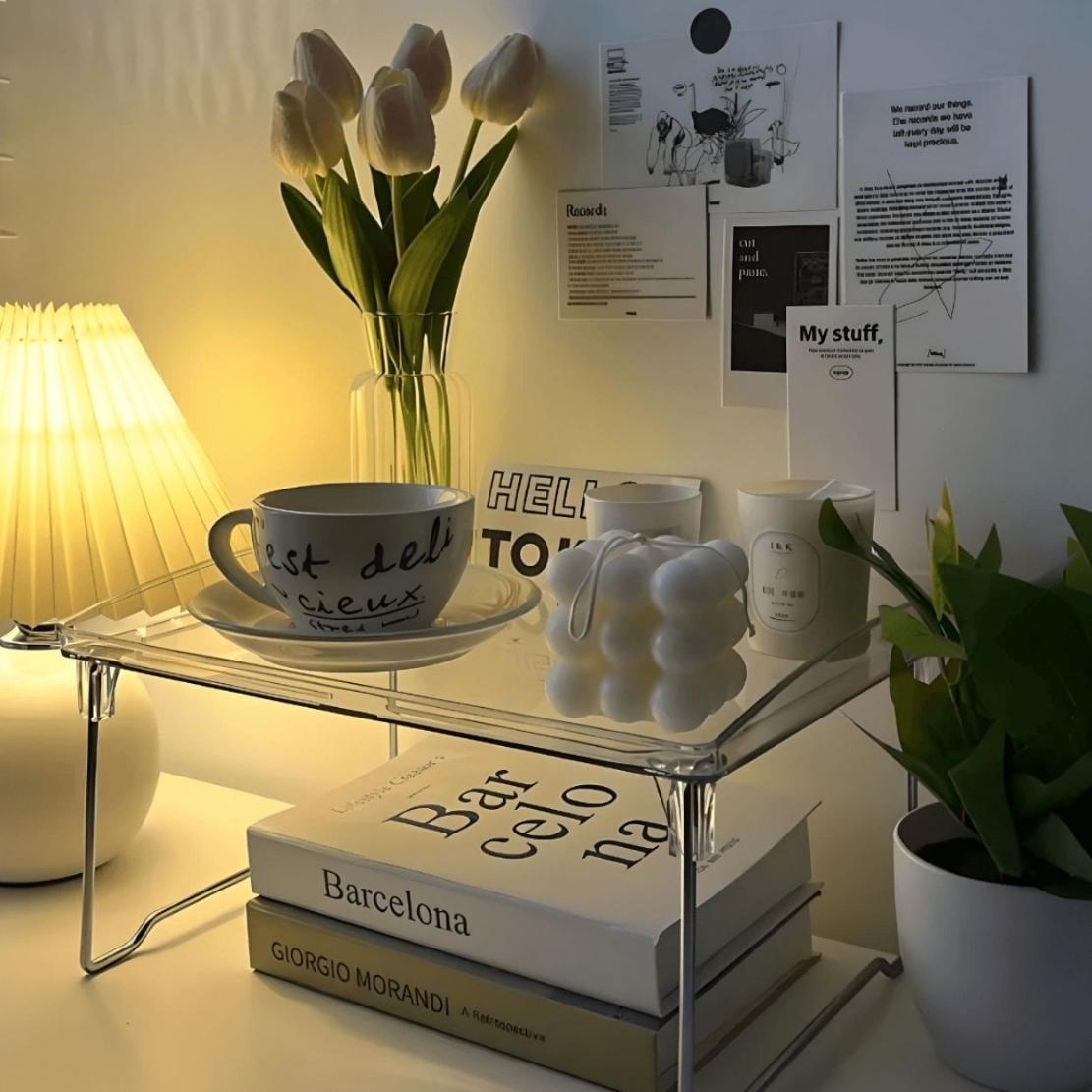 Foldable acrylic storage shelf with books, candle, mug and vase