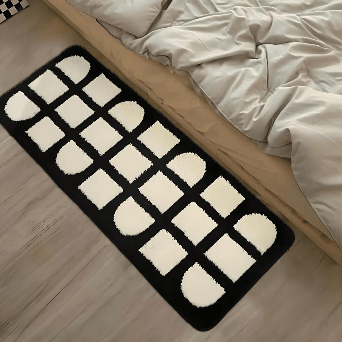 A bedside floor rug with a black and white geometrical design