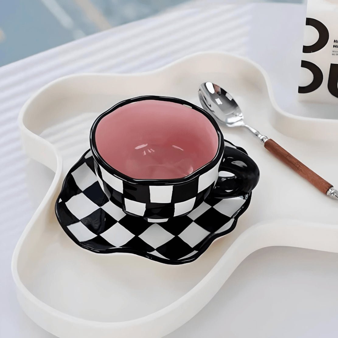 Black white pink checkerboard mug with saucer on food tray