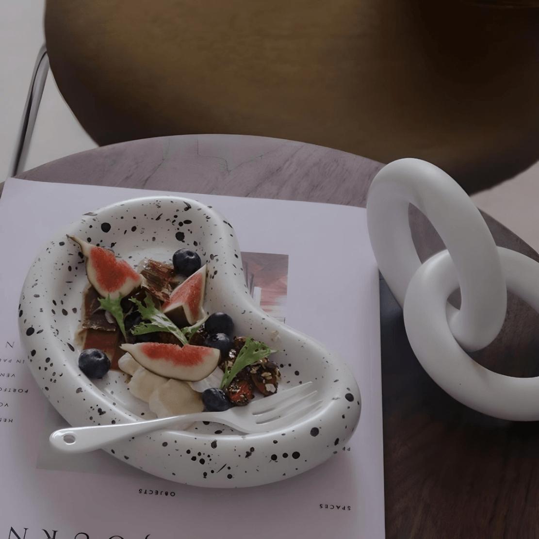 Bean shaped ceramic splash ink plate with salad on dining table