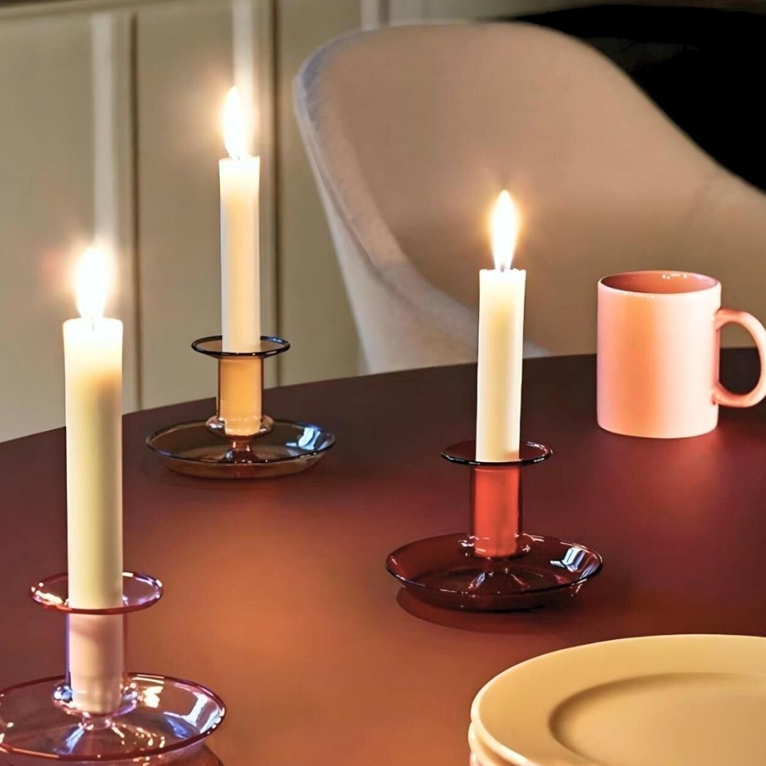 Simple glass candlestick holders with glowing candles