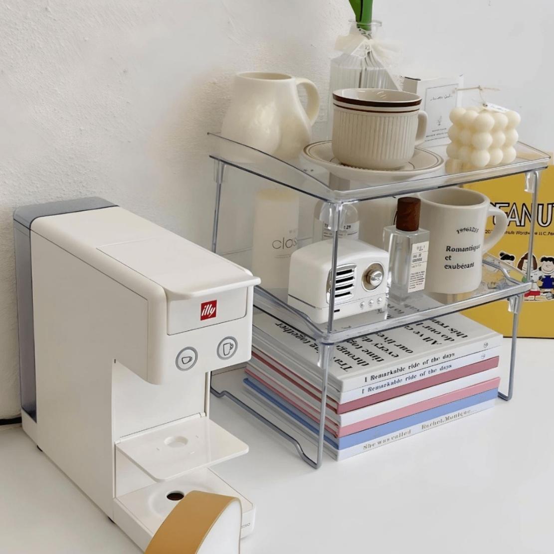 Foldable acrylic kitchen storage tray with mugs, candle, books & coffee machine