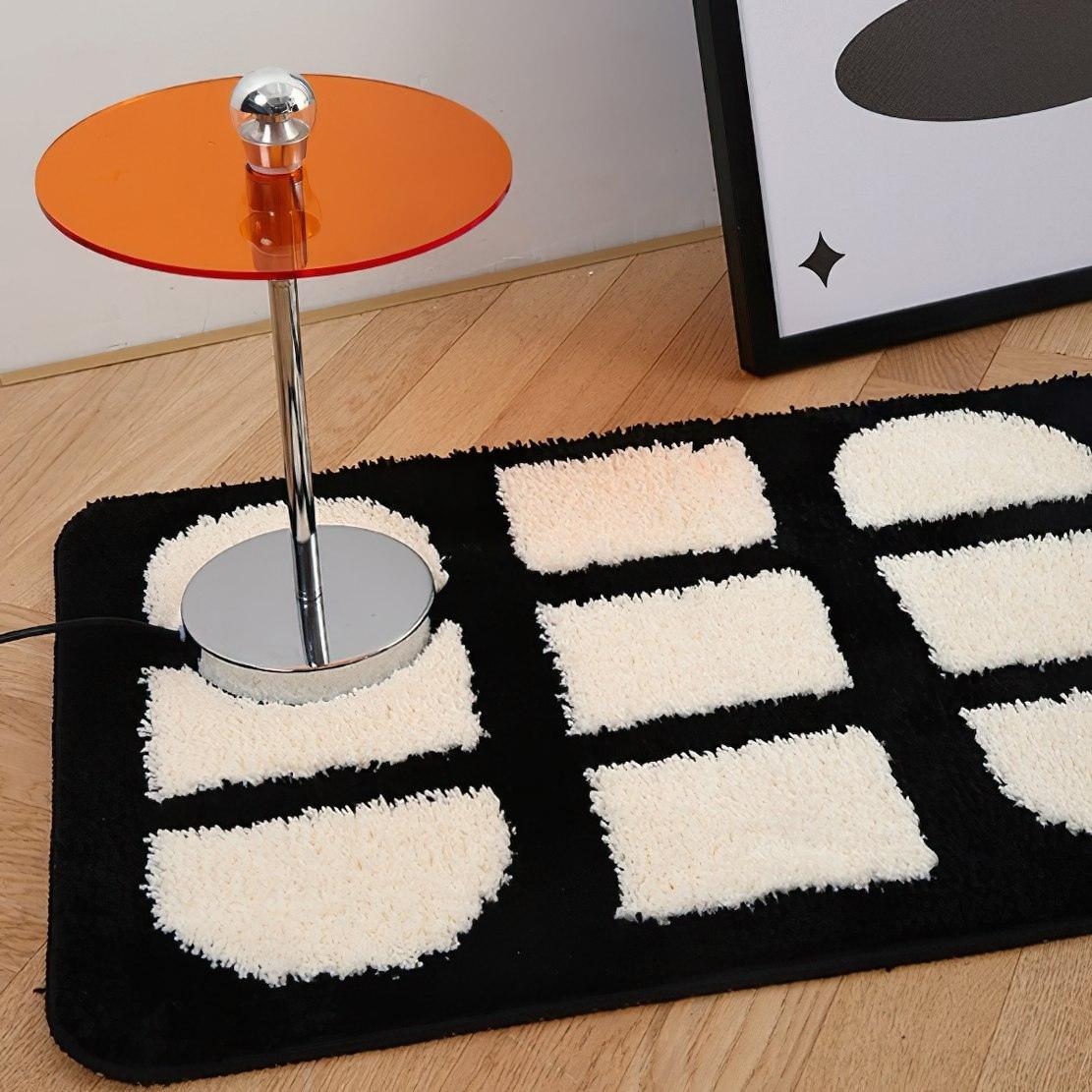 Black and white patterned rug with orange table lamp
