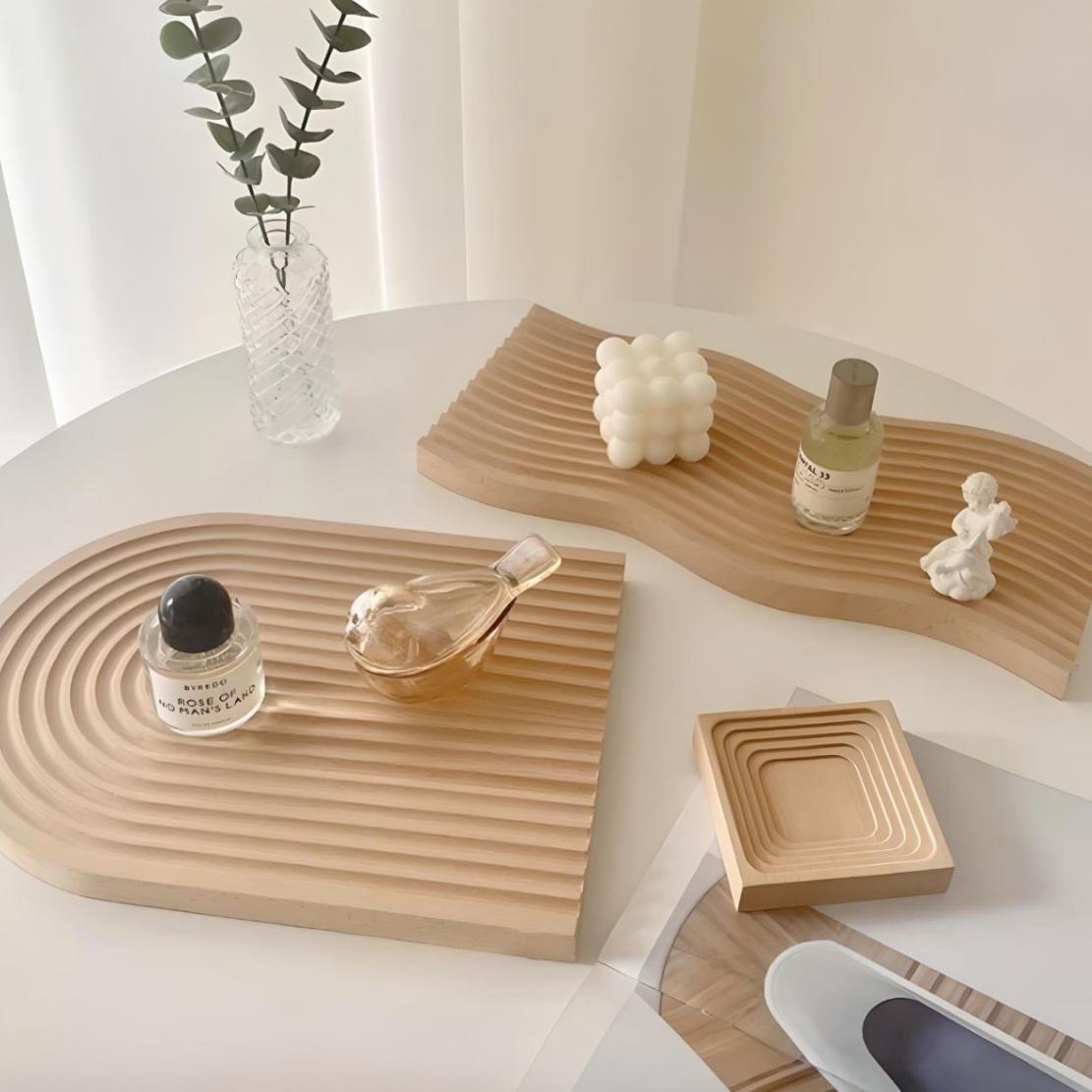 Light wood line tray in arch and wavy shape on table with cosmetics