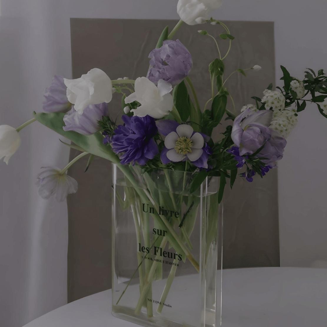 Transparent acrylic book vase with text and purple flower bouquet