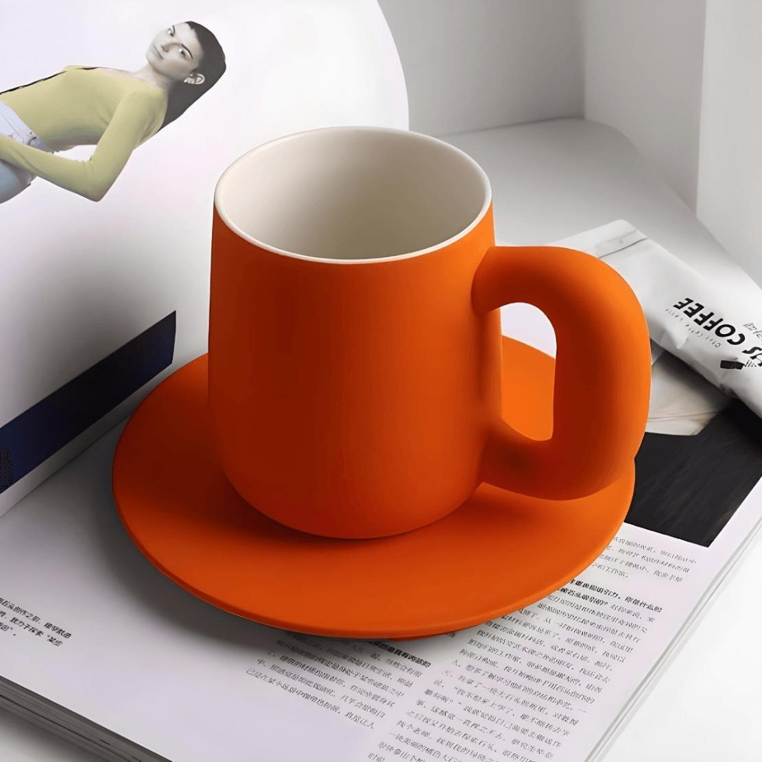 Orange ceramic coffee mug with saucer