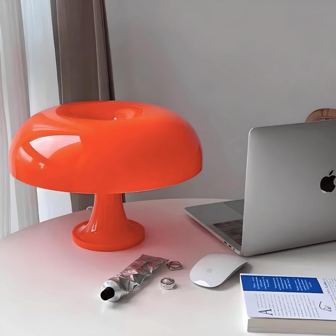Retro cloud orange mushroom lamp on office table with laptop