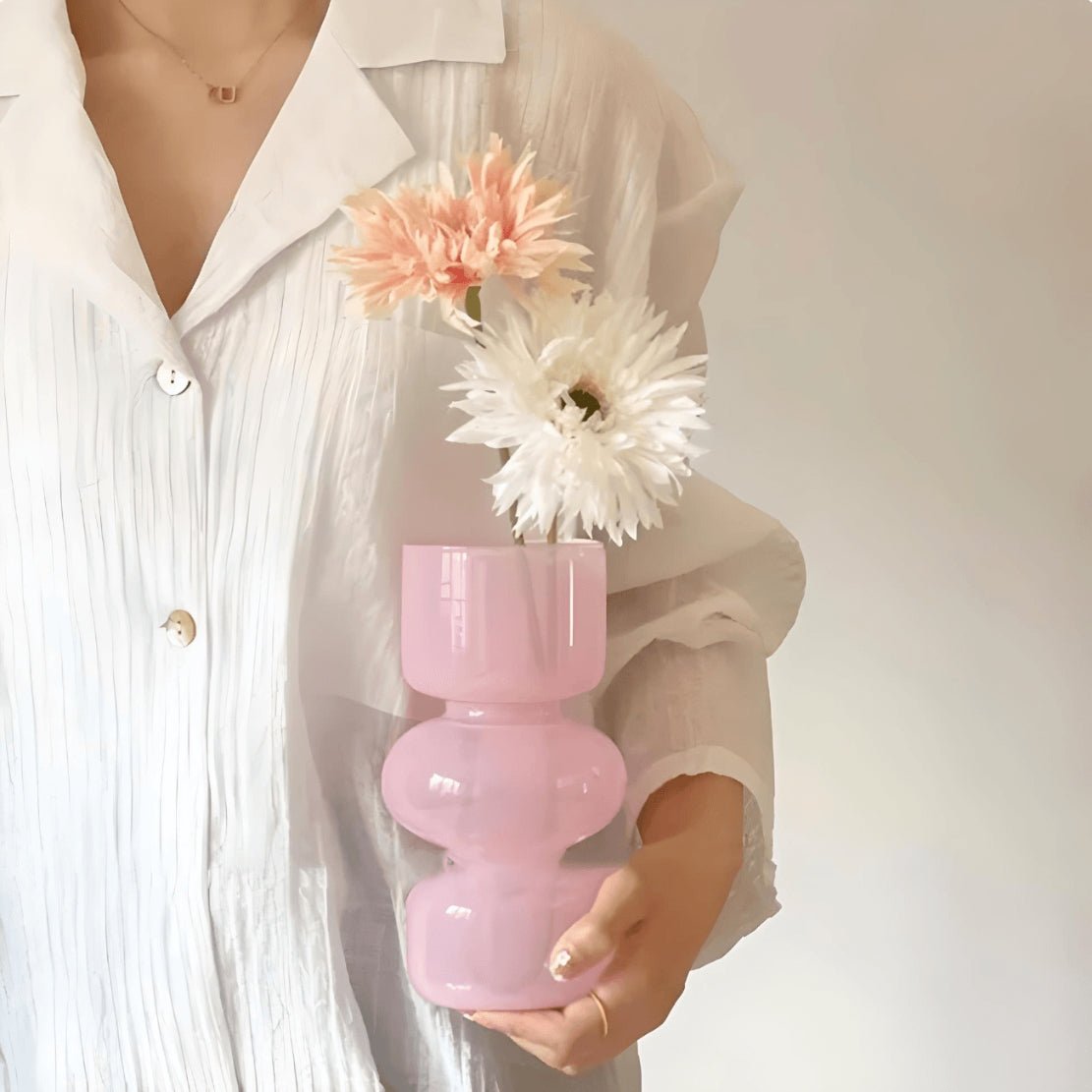 Woman holding pink geometric ball glass vase with white flowers