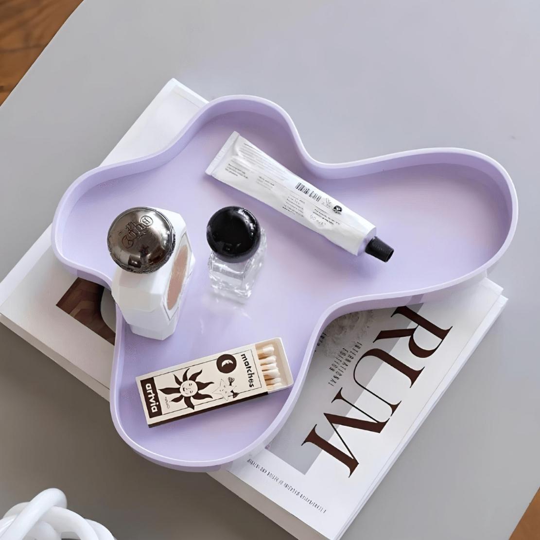 purple acrylic coffee table vanity tray with design magazine and trinkets.