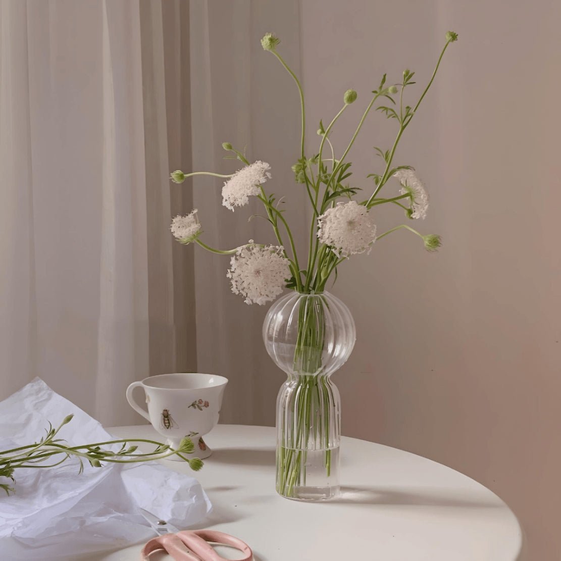 Elegant, tall ball glass vase with white flowers