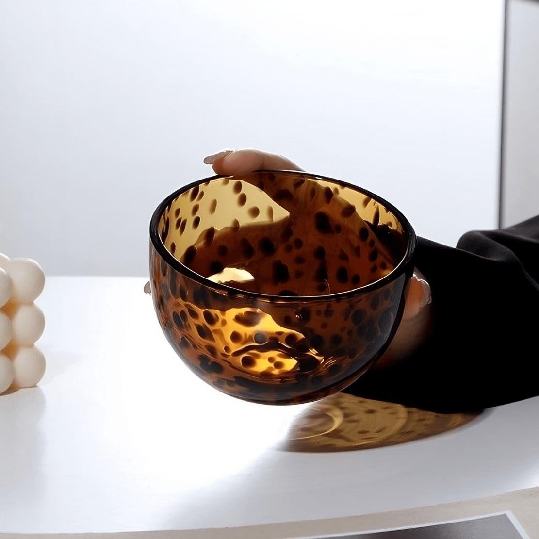 Hand holding brown tortoiseshell glass bowl