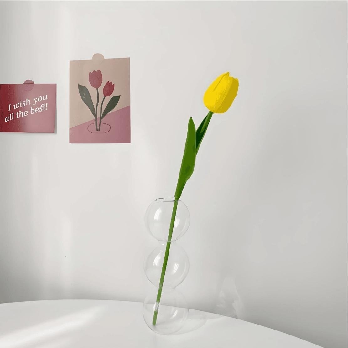 Transparent, layered glass ball vase with yellow tulip