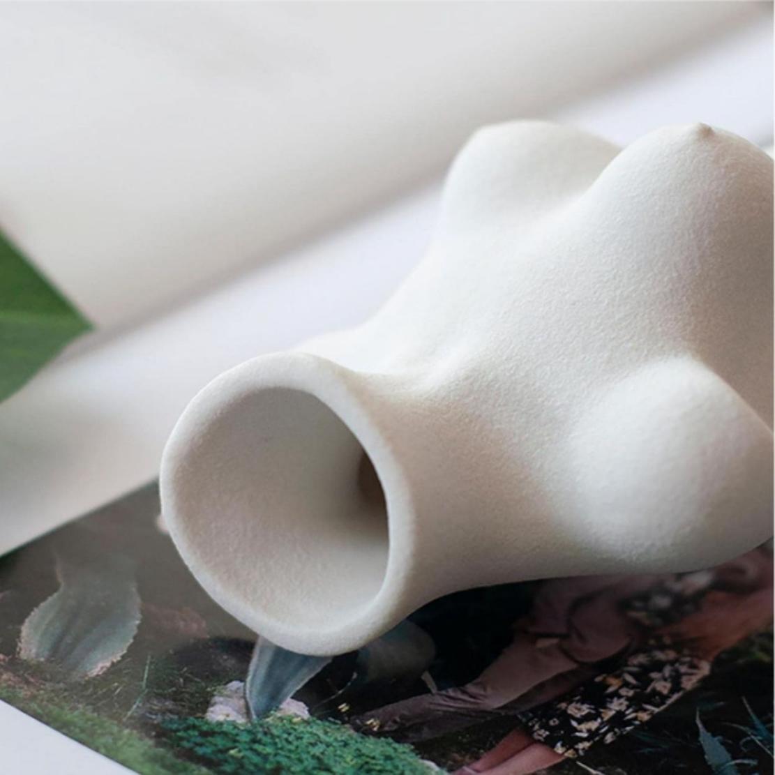 Closeup image of white, ceramic, Venus statue body vase
